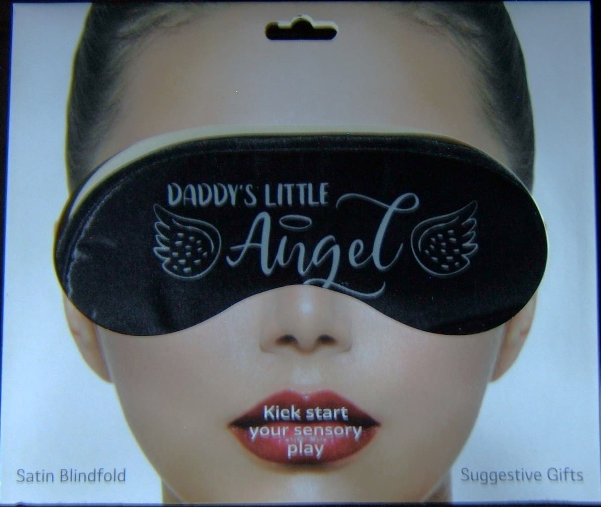 A woman wearing an eye mask with the words " daddys little angel ".