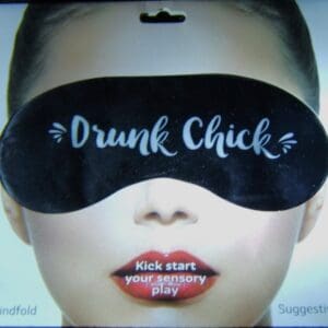 A woman wearing a black eye mask with the words drunk chick written on it.