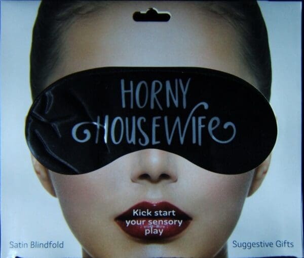 A woman wearing a black eye mask with the words " horny housewife."