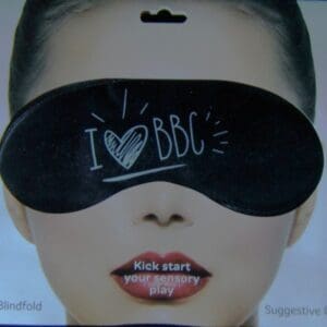 A woman wearing a blindfold with the words " i love bbc " written on it.