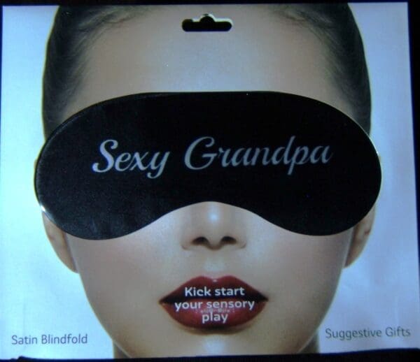 A woman wearing a black eye mask with the words sexy grandpa written on it.