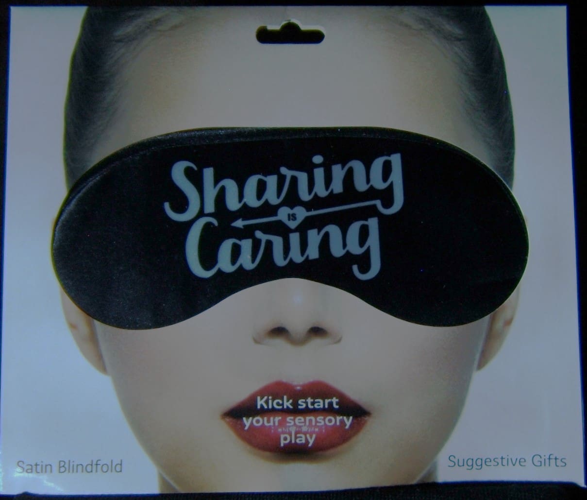 A woman wearing a blindfold with the words " sharing caring " written on it.