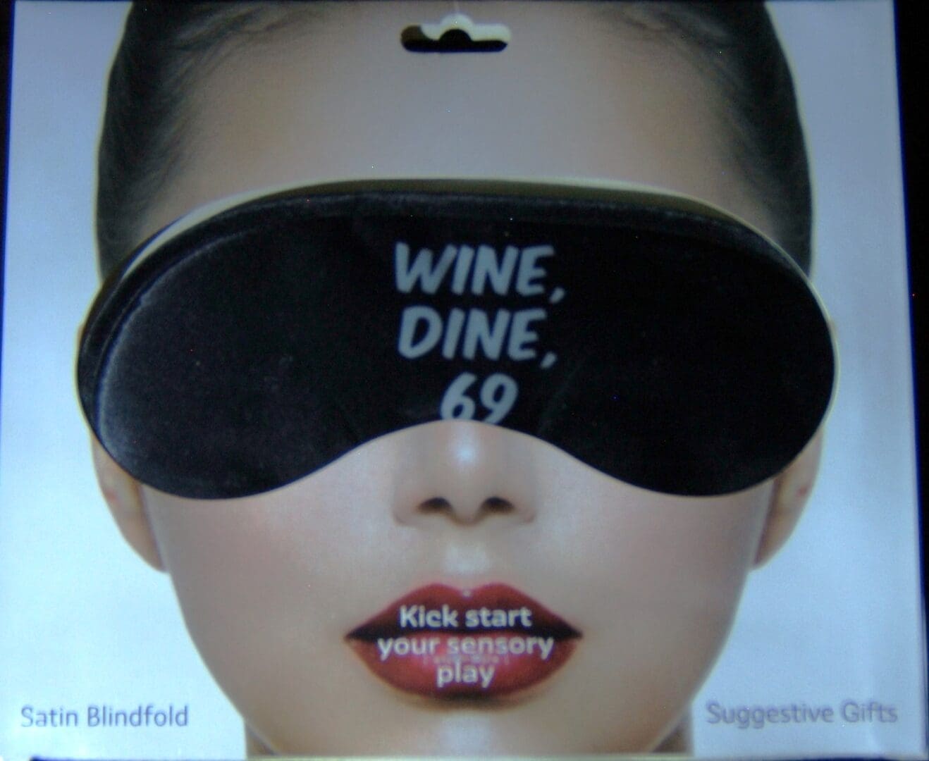 A woman wearing a blindfold and a wine glass.