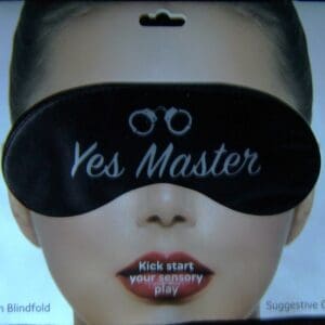 A woman wearing a black eye mask with the words " yes master " written on it.