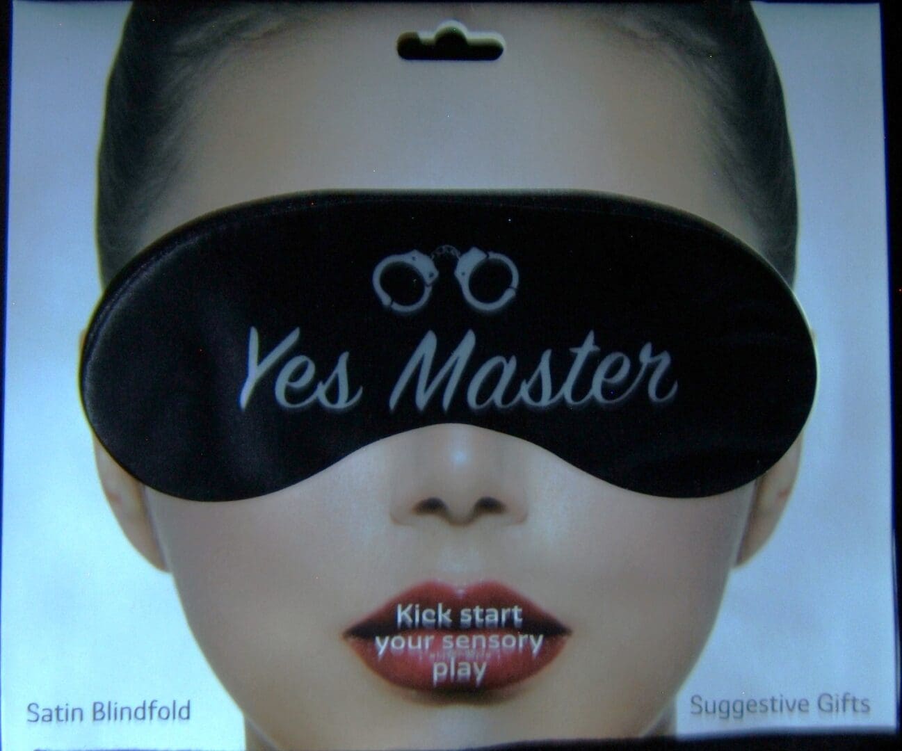 A woman wearing a black eye mask with the words " yes master " written on it.