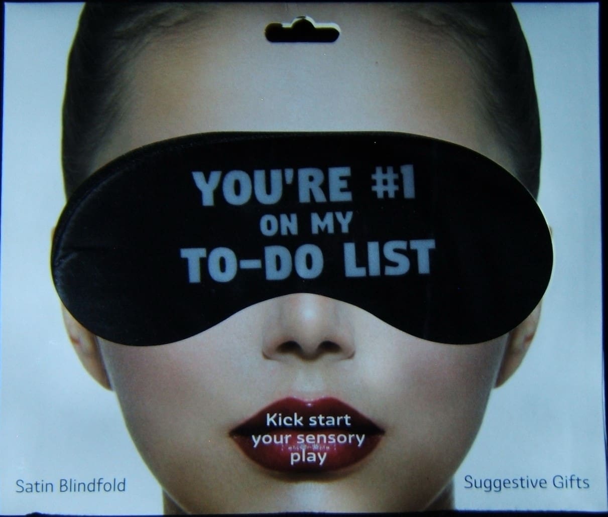 A woman with a blindfold is wearing a black eye mask.